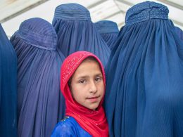 Una niña con velo rodeada de mujeres con burka o niqab en Afganistán © UNICEF/Osman Khayyam